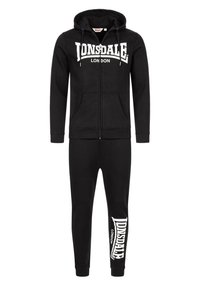 Zwarte trainingsbroek met een rits hoodie met een voorkant zak en een trekkoordkap, gecombineerd met tapered broek met een logo print.