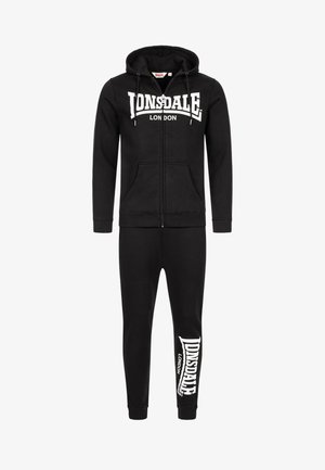 Crni trenerka koja uključuje duksericu na zip s prednjim džepom i kapuljačom na šnuru, u kombinaciji s uskim hlačama koje prikazuju print s logotipom.
