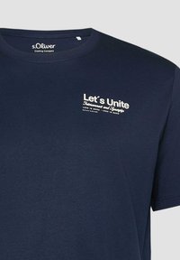 T-shirt bleu marine s.Oliver avec texte blanc « Let's Unite Interconnect and Synergize Less is More - Less is Done » sur le côté gauche de la poitrine.