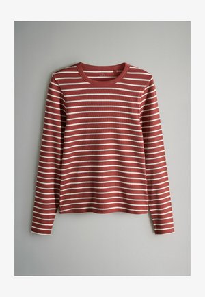 Pitkähihainen yläosa ruosteenpunaisena, valkoisilla vaakaraitoilla. Pyöreä pääntie ja sileä, pehmeä pinta. Rentoa istuvuutta.