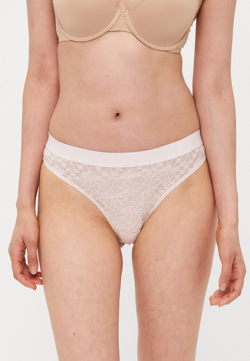 Lace bikini undertøy i lys rosa med en glatt elastisk midjebånd. Har blomster mønstre over hele lace-materialet.