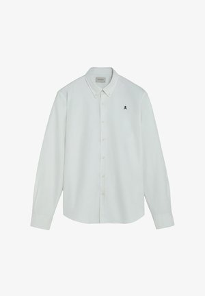 Chemise blanche à manches longues avec col boutonné et petit logo noir de tête de mort et os croisés sur la poitrine gauche.