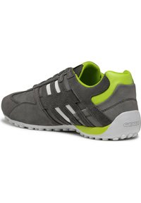 Sneaker in suede grigio con strisce bianche, accenti verdi e suola in gomma testurizzata dotata di fori di ventilazione, progettata per garantire traspirabilità.