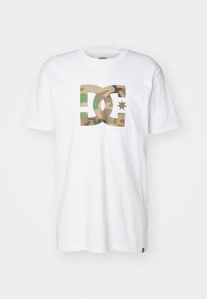 Witte T-shirt met korte mouwen en een ronde hals, voorzien van een groot DC-logo met camouflagepatroon en een ster in het midden aan de voorkant.