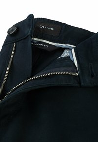 Pantaloni blu navy di vestibilità moderna con chiusura a zip e bottone, con rivestimento interno a motivo e dettagli in zip argentati. Tessuto in misto cotone.