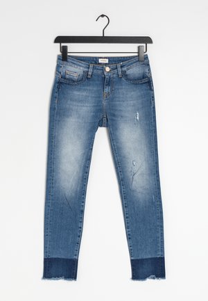 Skinny blue denim jeans with light fading, rips, and a frayed hem. Features classic pockets and a metal button closure at the waist.