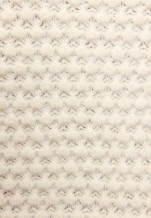 Gros plan sur un tissu tricoté de couleur crème avec un motif doux et texturé de petites clusters en relief et de points entrelacés.