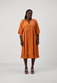 Vestido laranja, até aos joelhos, com um corte descontraído, mangas curtas, bainha com babados e decote atado. Tecido leve e texturizado.