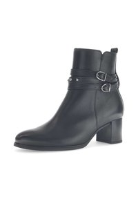 Bottines en cuir noir avec un bout arrondi, un talon bloc de hauteur intermédiaire, et deux sangles avec des boucles en métal et des clous décoratifs.
