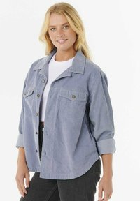 Giacca camicia in corduroy azzurro chiaro con due tasche sul petto, chiusura a bottoni e maniche arrotolate. Colore solido con tessuto testurizzato.
