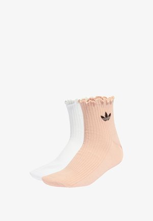 Ribbowane skarpetki do kostek w różowym i białym kolorze, z falbaną na górze i czarnym akcentem z logo. Wykonane z miękkiego materiału, zapewniającego wygodne dopasowanie.