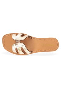 Flat sandal with a metallic cracked leather upper and cut-out design. Features a tan sole and stitched detailing. Simple and open style.