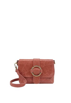 Petit sac bandoulière rose texturé avec sangle détachable et grande boucle circulaire dorée sur le rabat avant.