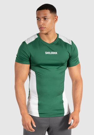 Groene sportieve shirt met witte zijkanten en een v-hals, gemaakt van soepel, rekbaar materiaal. Bevat het merk "SMILODOX" op de voorkant.