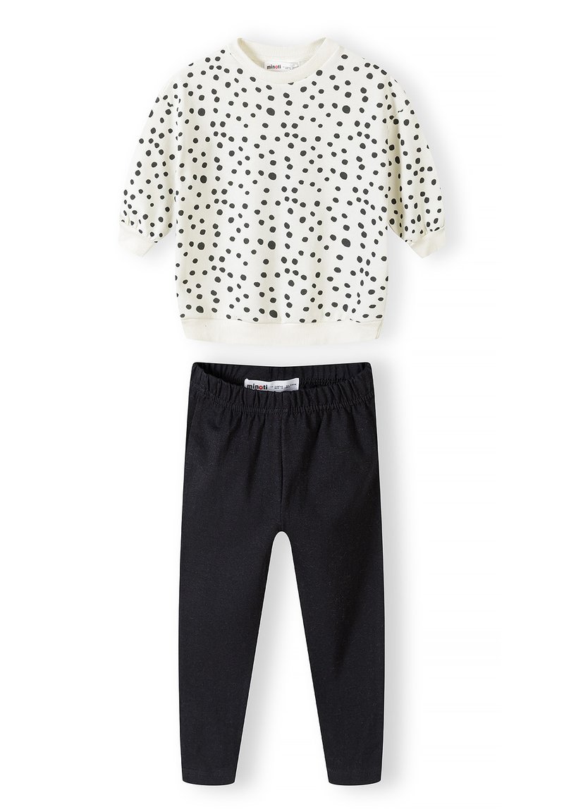 Lys cremet sweatshirt med sorte prikker og korte ærmer, kombineret med sorte stræk leggings. Blødt bomuldsstof, afslappet pasform.