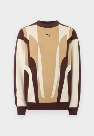 Suéter de cuello redondo con patrones geométricos abstractos en beige, marrón y crema, y pequeño logo de Puma en el pecho.