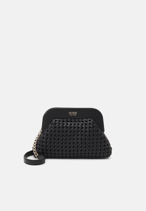 Zwarte geweven clutch met gouden kettingriem en het logo "GUESS EST 1981" op het gladde bovenpaneel, tentoongesteld tegen een witte achtergrond.