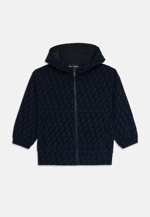 Navy blue hooded jacket with front zipper, elastic cuffs, and all-over EA logo pattern, designed for children.