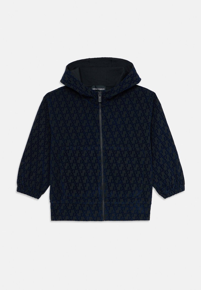 Giacca a vento blu navy con cappuccio, chiusura frontale con zip, polsini elasticizzati e motivo con logo EA su tutta la superficie, progettata per bambini.