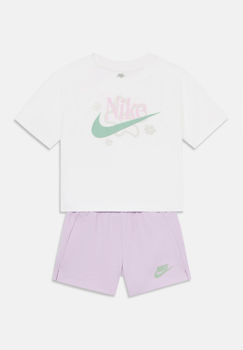 White cotton t-shirt with pink and mint Nike logo, paired with light purple shorts featuring small green Nike logo on the side.