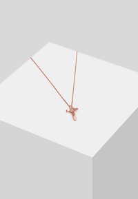 Rosa guld halskæde med en unik korsvedhæng, der har et struktureret design og en lille ædelstenskant. Kæden er tynd og delikat.