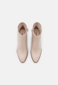 Botines beige de cuero suave, con punta afilada y cierre con cremallera lateral. Talla 37, con un diseño minimalista.