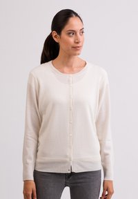 Ljusgrön cardigan gjord av mjukt tyg, med rund halsringning och knäppning framtill, ribbade kanter och långa ärmar.