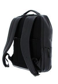 Mochila negra con correas acolchadas de malla, material sintético elegante, compartimentos con cremallera y un diseño minimalista. Dimensiones adecuadas para el uso diario.