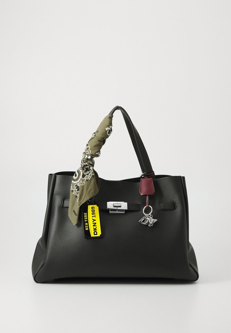 Bolsa de mão de couro preto com um design estruturado, apresentando um lenço estampado verde preso à alça e uma etiqueta de destaque em borgonha.