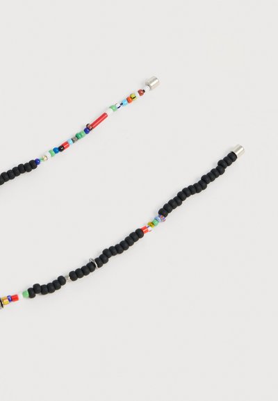 Κολιέ γυαλιών με κυρίως μαύρες χάντρες, επισημασμένο με μικρές πολύχρωμες χάντρες και ασημένια τελειώματα και στις δύο πλευρές.