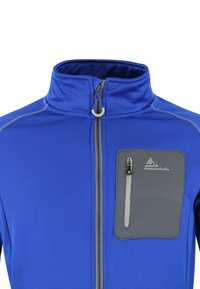 Giacca in pile blu con colletto alto, zip frontale e tasca sul petto grigia. Presenta cuciture a contrasto e un logo sulla tasca.