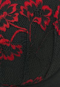 Svart blondehatt med et rødt blomstermønster, med intrikate detaljer og en teksturert overflate. Designet har en buet form og mykt stoff.