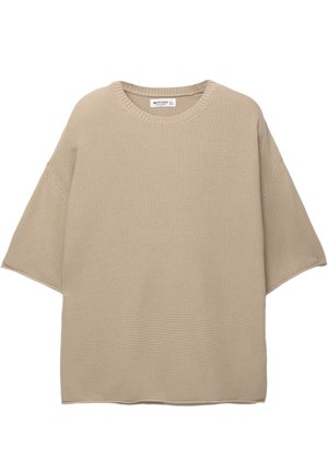 Pullover beige oversize realizzato in tessuto lavorato a maglia con scollo rotondo e maniche corte, caratterizzato da un orlo dritto semplice.