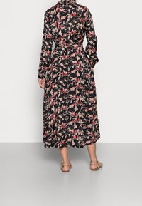 Kwiatowa sukienka midi w ciemnym materiale z różowymi i beżowymi wzorami. Posiada długie rękawy, pasek wiązany w talii oraz rozkloszowany dół. Noszona z sandałami w kolorze koniakowym.