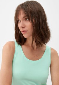 Mintgrünes, ärmelloses Top aus weichem, glattem Stoff, mit runder Ausschnittform und taillierter Silhouette.