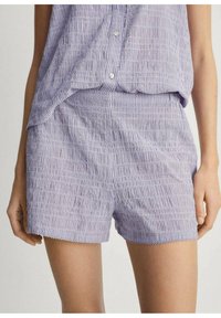 Lila och vita randiga shorts gjorda av lätt tyg med en mjuk textur, med en vågig nederkant och en avslappnad passform.