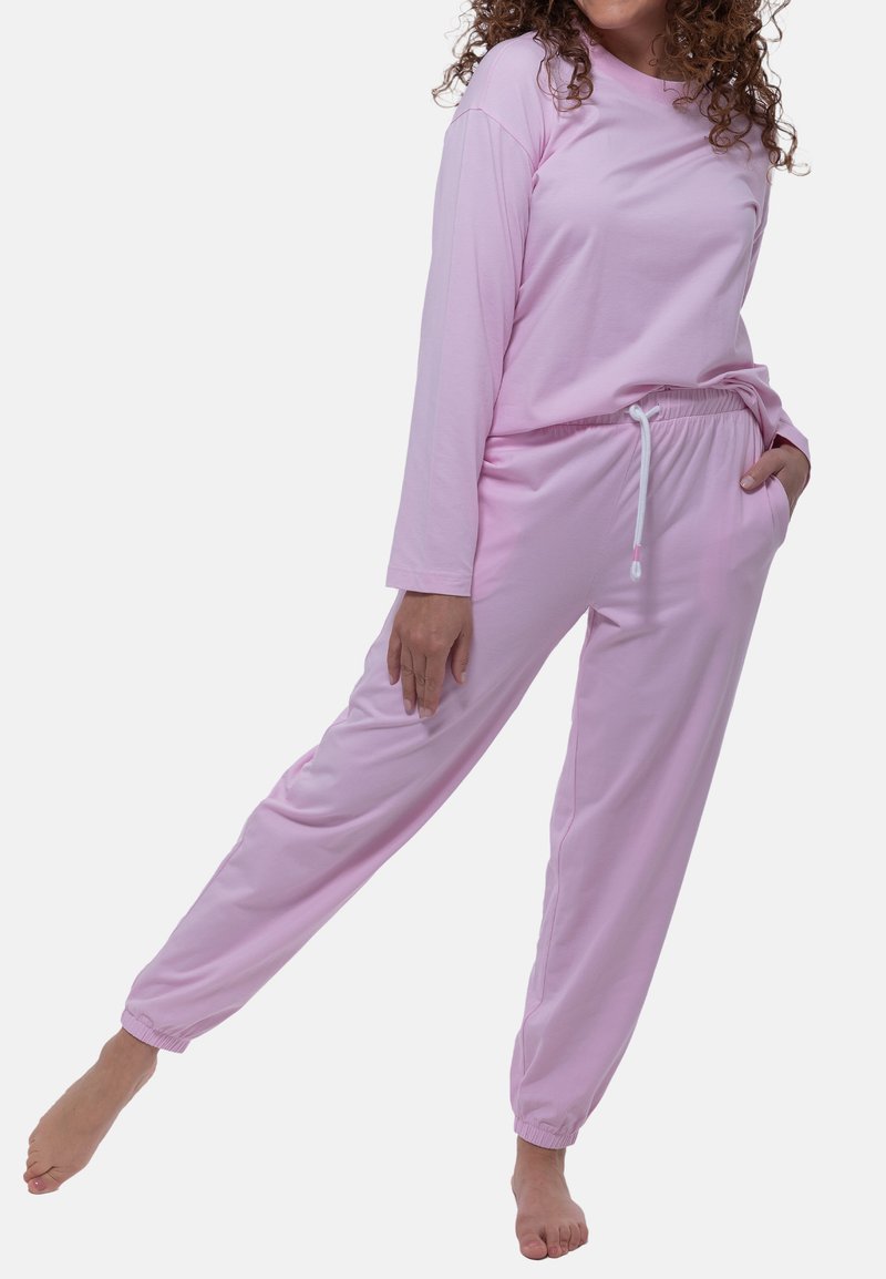 Ljusrosa långärmad topp med rund hals och avslappnad passform, parat med matchande lätta joggers med elastisk midja och fickor.