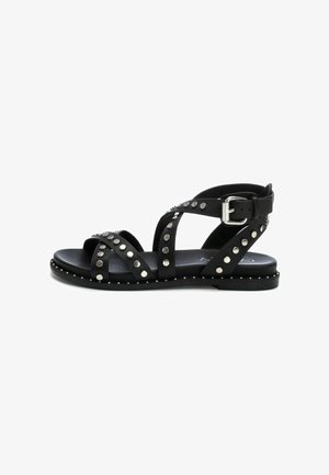 Zwarte leren sandalen met studs, voorzien van meerdere banden en een gesp-sluiting. Platte zool met metalen studs langs de rand.
