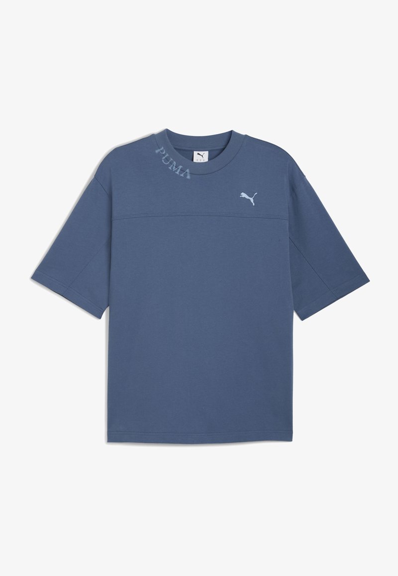 Sininen puuvillapaita lyhyillä hihoilla, jossa on huomaamaton "PUMA"-teksti kaula-aukossa ja pieni logo rinnassa. Silkkinen pinta.