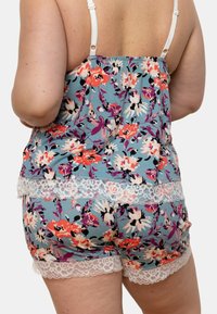 Ensemble de pyjama à motifs floraux en bleu, doté de délicates bordures en dentelle blanche et de bretelles spaghetti ajustables, avec une coupe décontractée au niveau du dos.