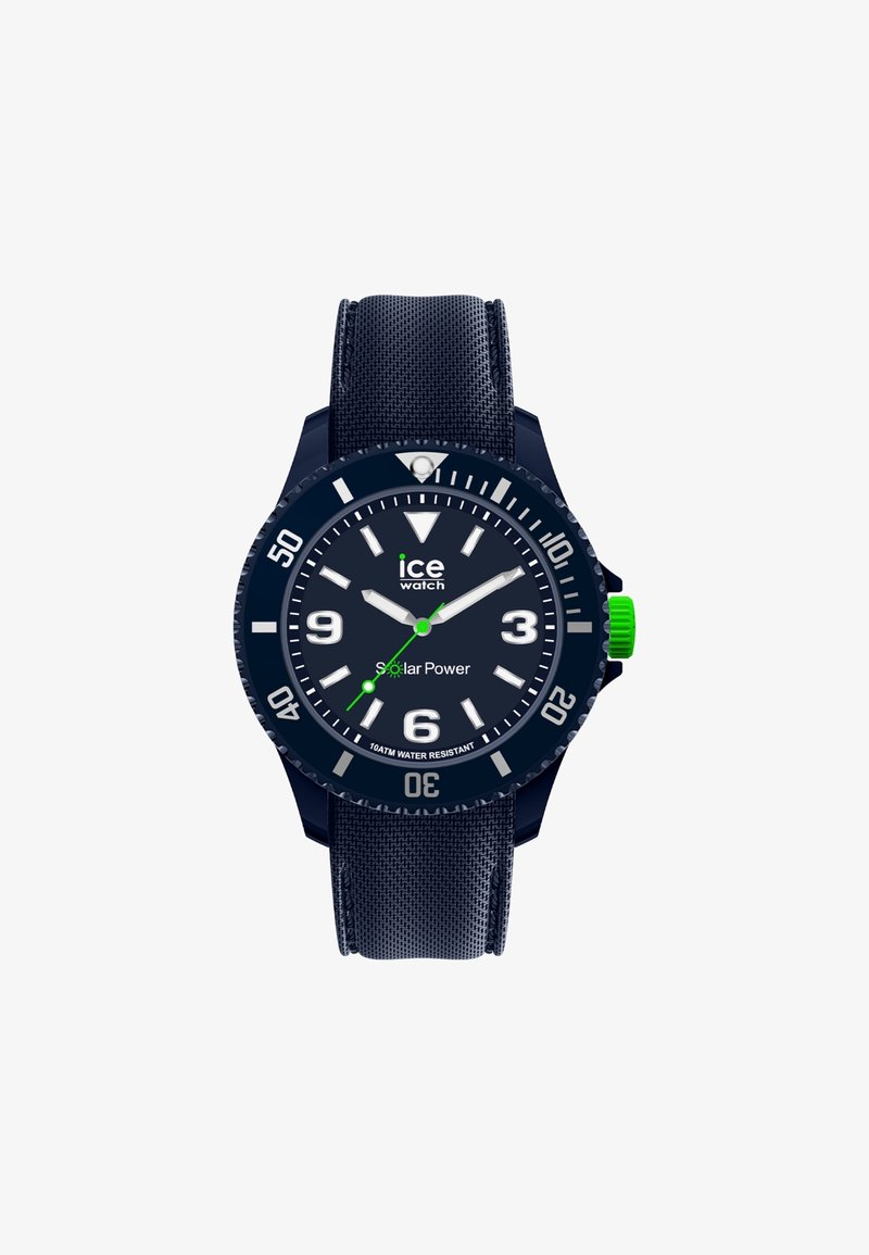 Tamsiai mėlynas saulės energiją vartojantis laikrodis su tekstūruota juosta, dideliais baltais valandos žymėjimais ir žaliu akcentu ant karūnėlės. Atsparus vandeniui iki 10 ATM.