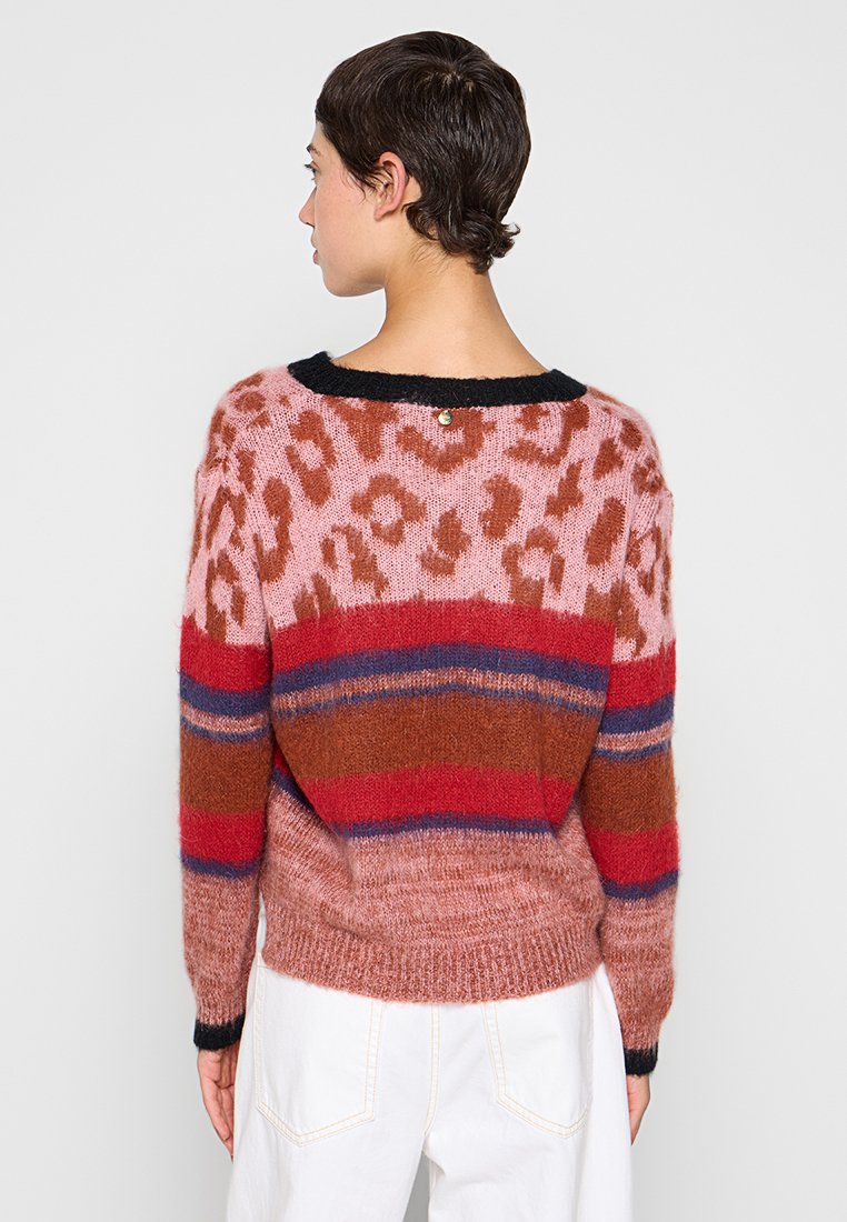 Roze en roest gestreepte trui met luipaardprint, zwarte halslijn en textuurgebreid. Heeft een knoopdetail aan de achterkant.