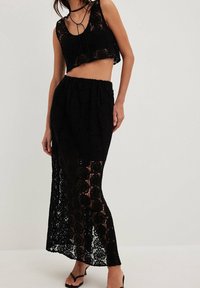 Sort hækleto-delt sæt med en cropped tanktop med bindebånd og en lang nederdel med et tekstureret, blondemønster.