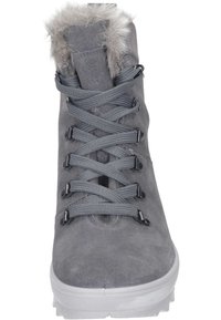 Botín de ante gris con cuello de pelo sintético, presenta cordones grises, ojales de metal y una suela de goma blanca. Superficie texturizada y diseño duradero.
