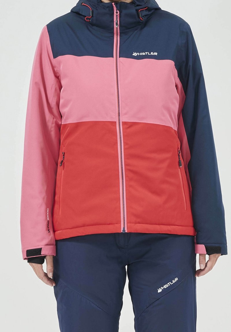 Giacca da sci a blocchi di colore con pannelli blu navy, rosa e rossi. Realizzata in tessuto morbido, con zip frontale, cappuccio e polsini regolabili.