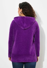 Felpa con cappuccio viola in un tessuto morbido e texturizzato. Presenta un orlo e dei polsini a coste, con una vestibilità casual e rilassata e maniche lunghe.