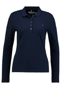 Marinblå långärmad pikétröja i bomullsblandning med ribbad krage, knappslå och liten logotypdetalj på bröstet. Slät textur.