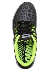 Chaussure de course Nike avec motif léopard noir et gris, lacets noirs, accents vert néon et texte "NIKE SHIELD PACK" à l'intérieur de la semelle.