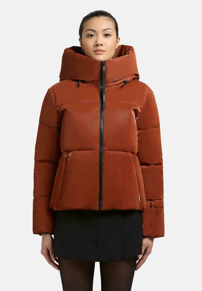 Giacca a vento rossa con colletto alto e chiusura a zip. Presenta tasche laterali e un design leggermente accorciato. Realizzata in un materiale liscio.