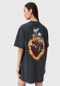 Czarny bawełniany, oversize'owy t-shirt z graficznym sercem i kwiatowym wzorem na plecach, z bogatymi kolorami i szczegółami. Krótkie rękawy.